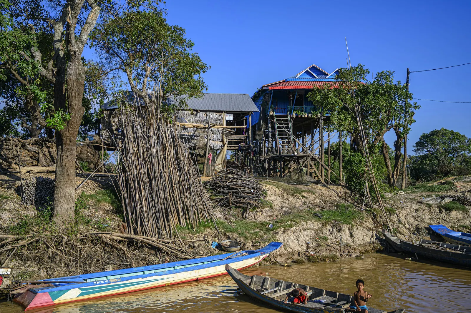 Lancha navegando un río junto a viviendas ribereñas