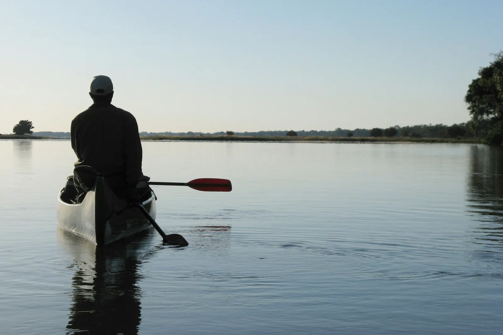 Persona remando en canoa al atardecer